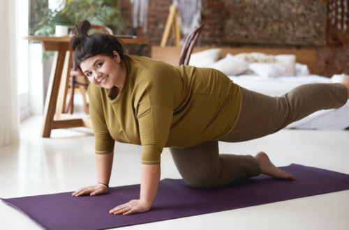 Femme qui fait des exercices pour son dos à la maison car elle a des douleurs lombaires